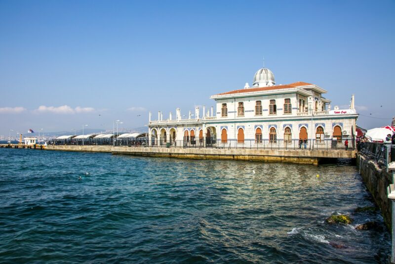 A large white building sitting on the side of a body of water