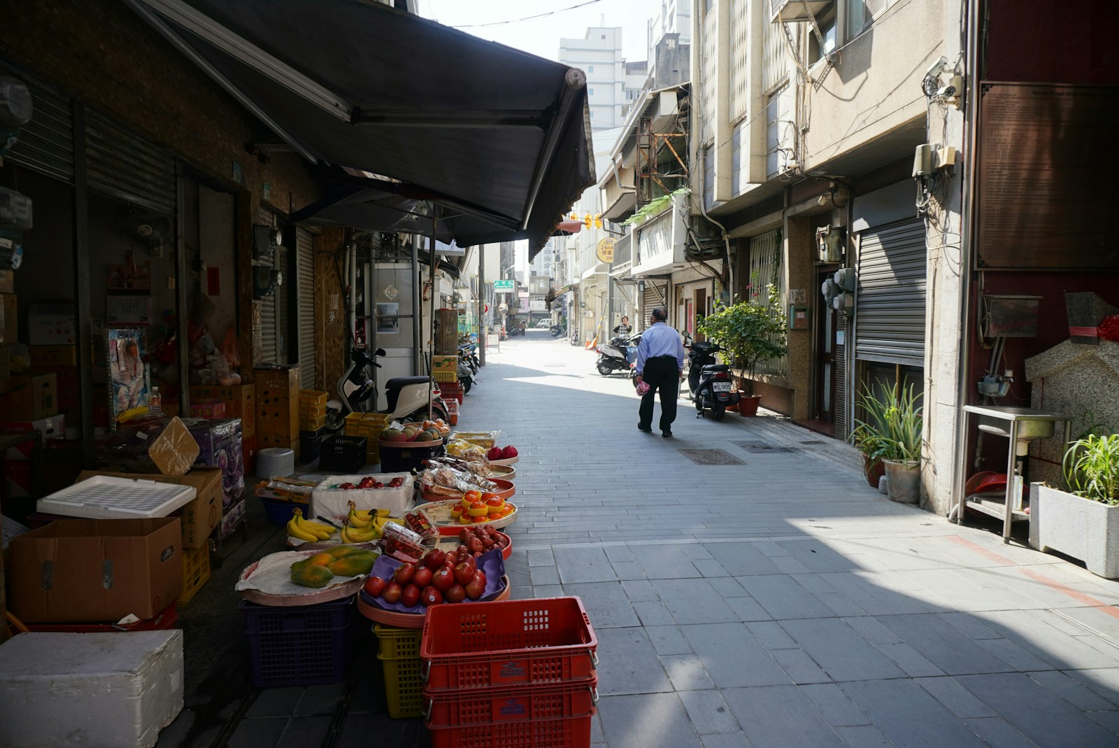 Photo by Rong A man walking down a street next to a building