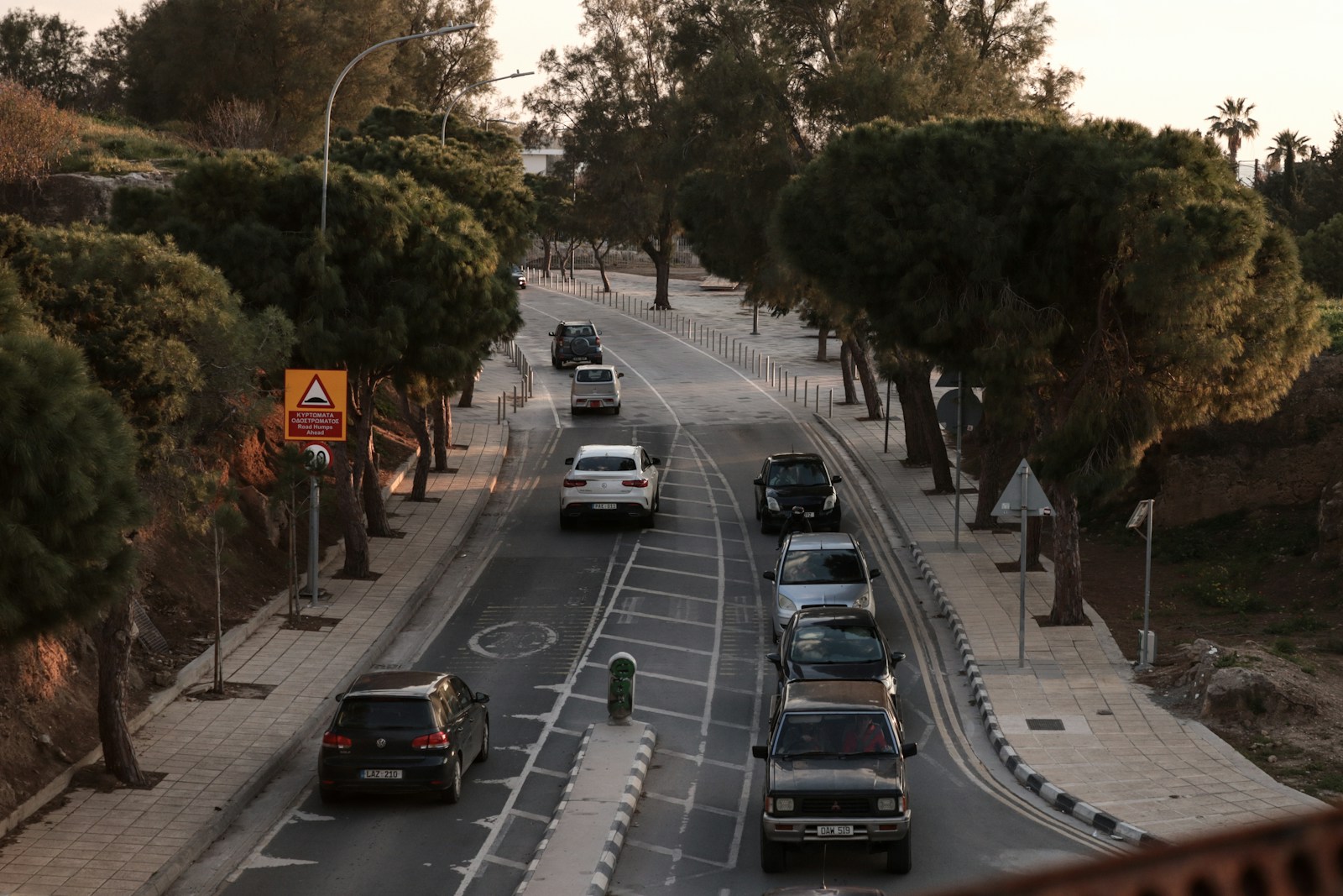 a street filled with lots of traffic next to trees