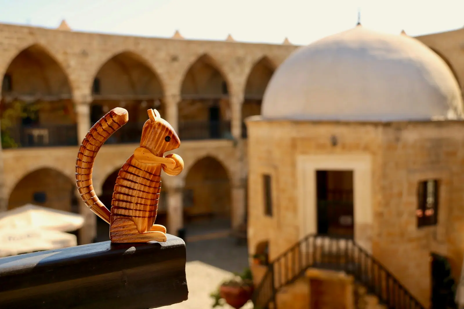 a cat figurine sitting on a ledge in front of a building