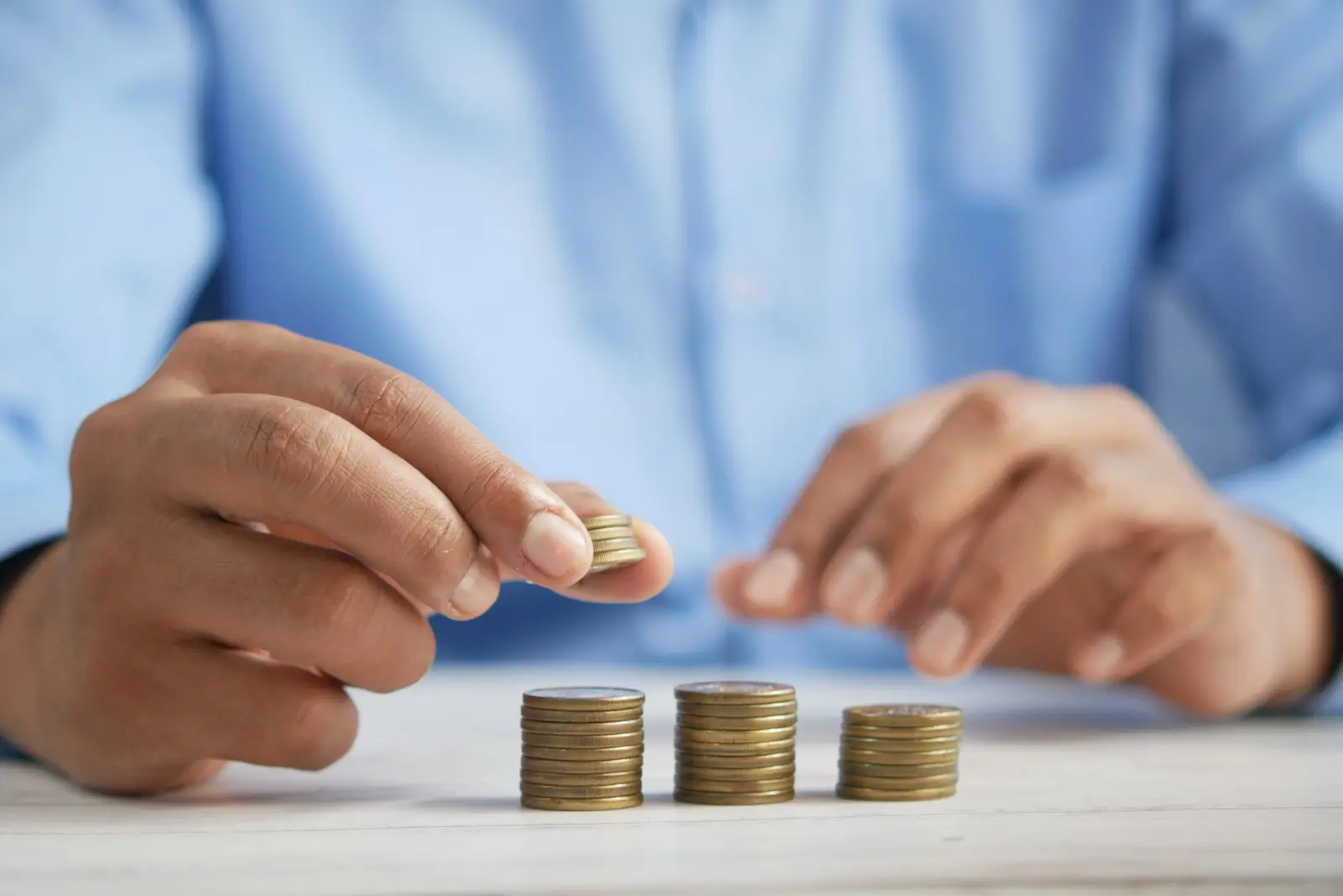 Photo by Towfiqu barbhuiya a person stacking coins on top of a table