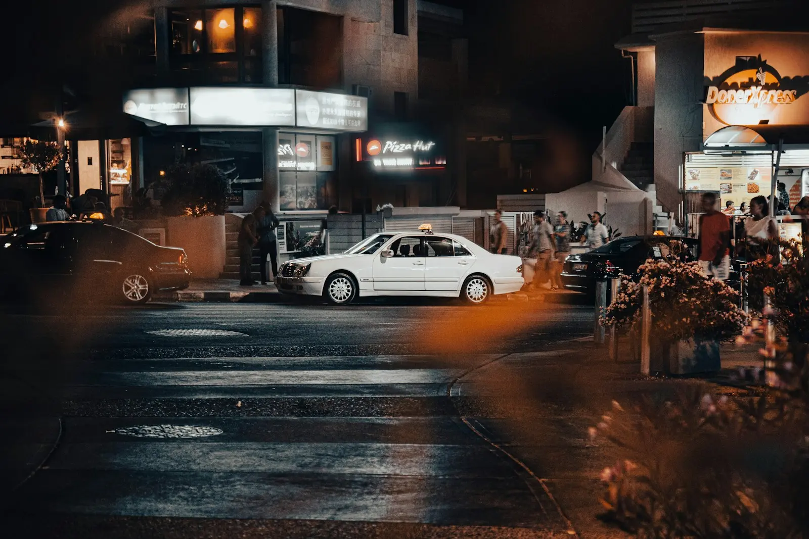 a white car on a street at night